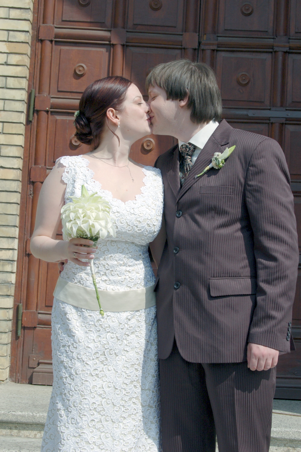 Newlyweds kiss on the church steps