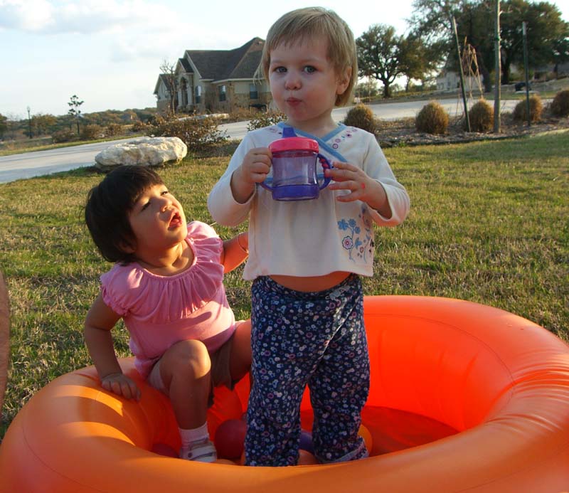 E (standing) with a friend in an inflatable pool