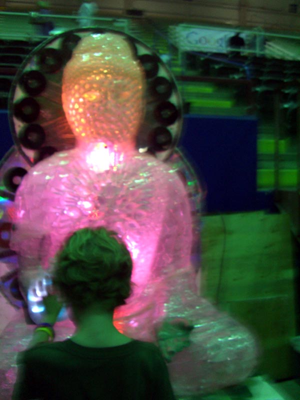 A child touches the hand of a Buddha-robot at the Maker Faire 2007