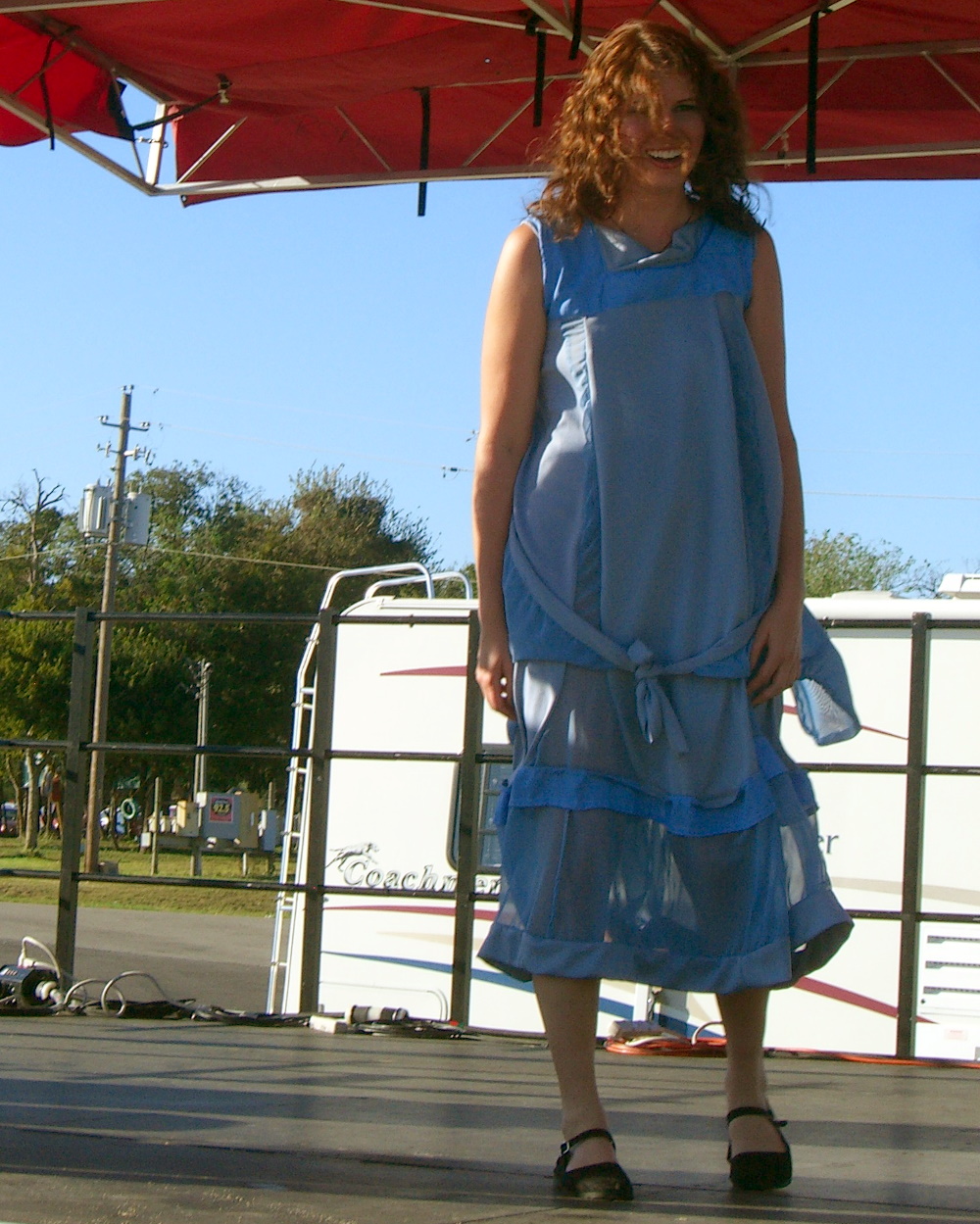 A blue dress with tiers and a knotted fabric belt, made of recycled clothing at Maker Faire 2007