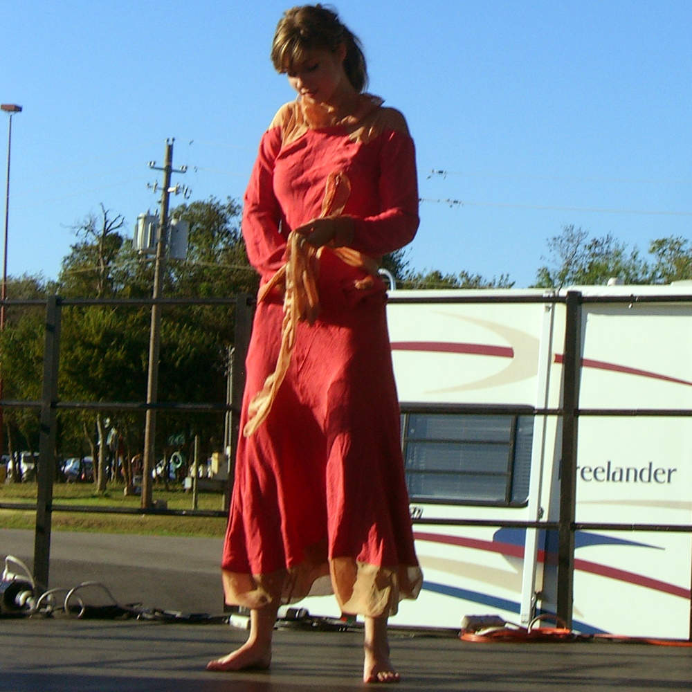 A red dress, or perhaps loose overalls, with yellow trim and yellow sash, made of recycled materials at Maker Faire 2007