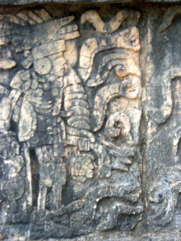 A priest holds a severed head - a Mayan carving in Chichen Itza.